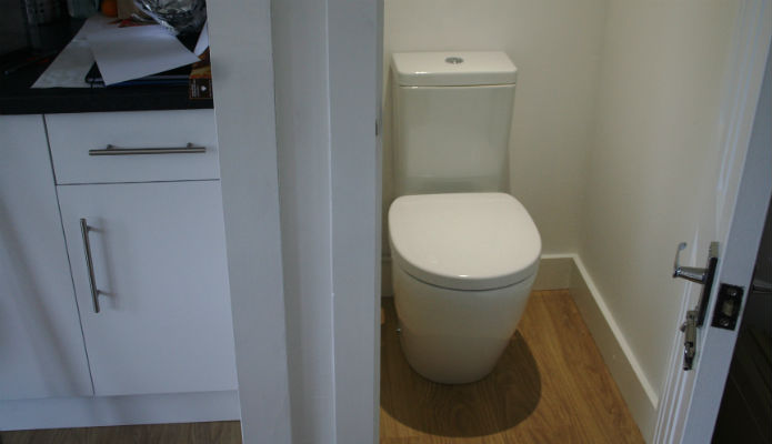 Photograph of compact toilet within a large garden room